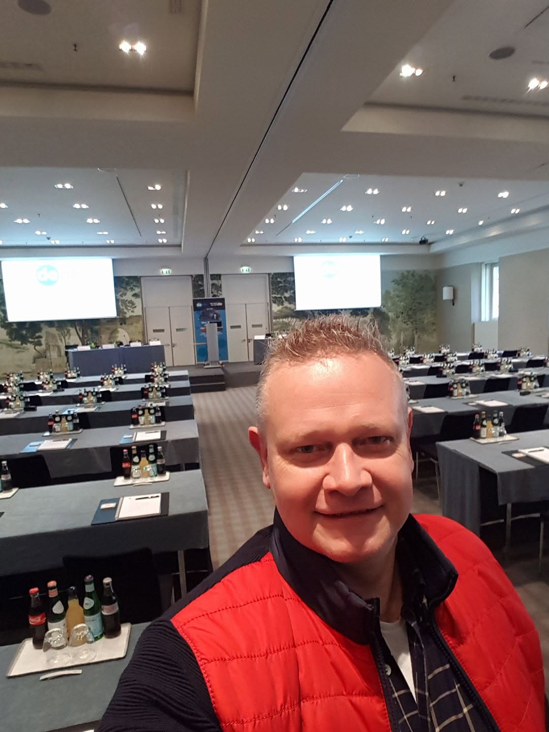 Leo Kobes in einem Veranstaltungssaal, im Hintergrund zwei Projektionen der DENIC